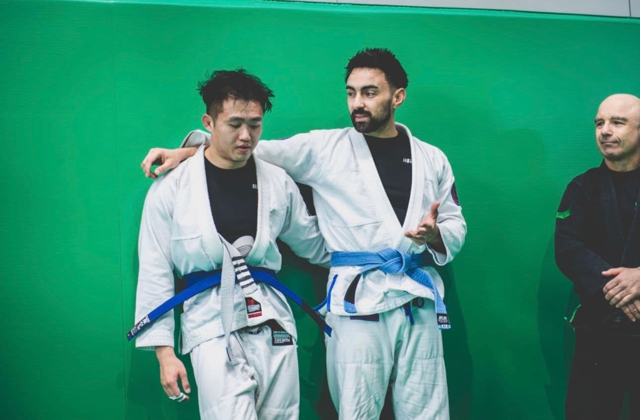 Two newly graded blue belts that have trained together from 4 stripe BJJ white belts to blue