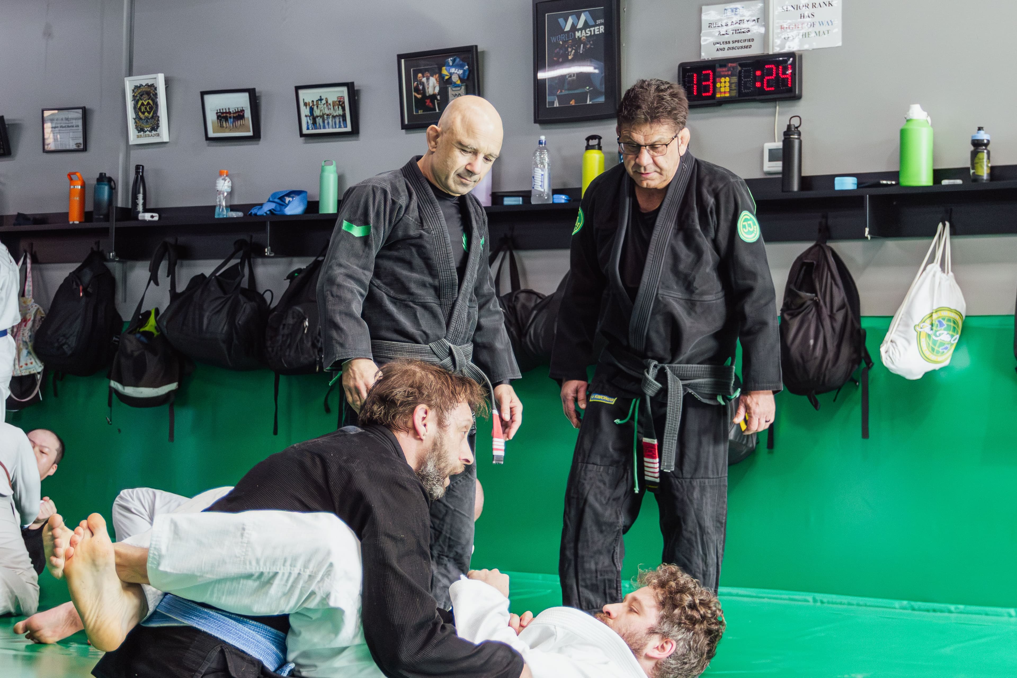 Brazilian Jiu-Jitsu instructors observing students as they practise techniques during a busy class at Renegade BJJ.