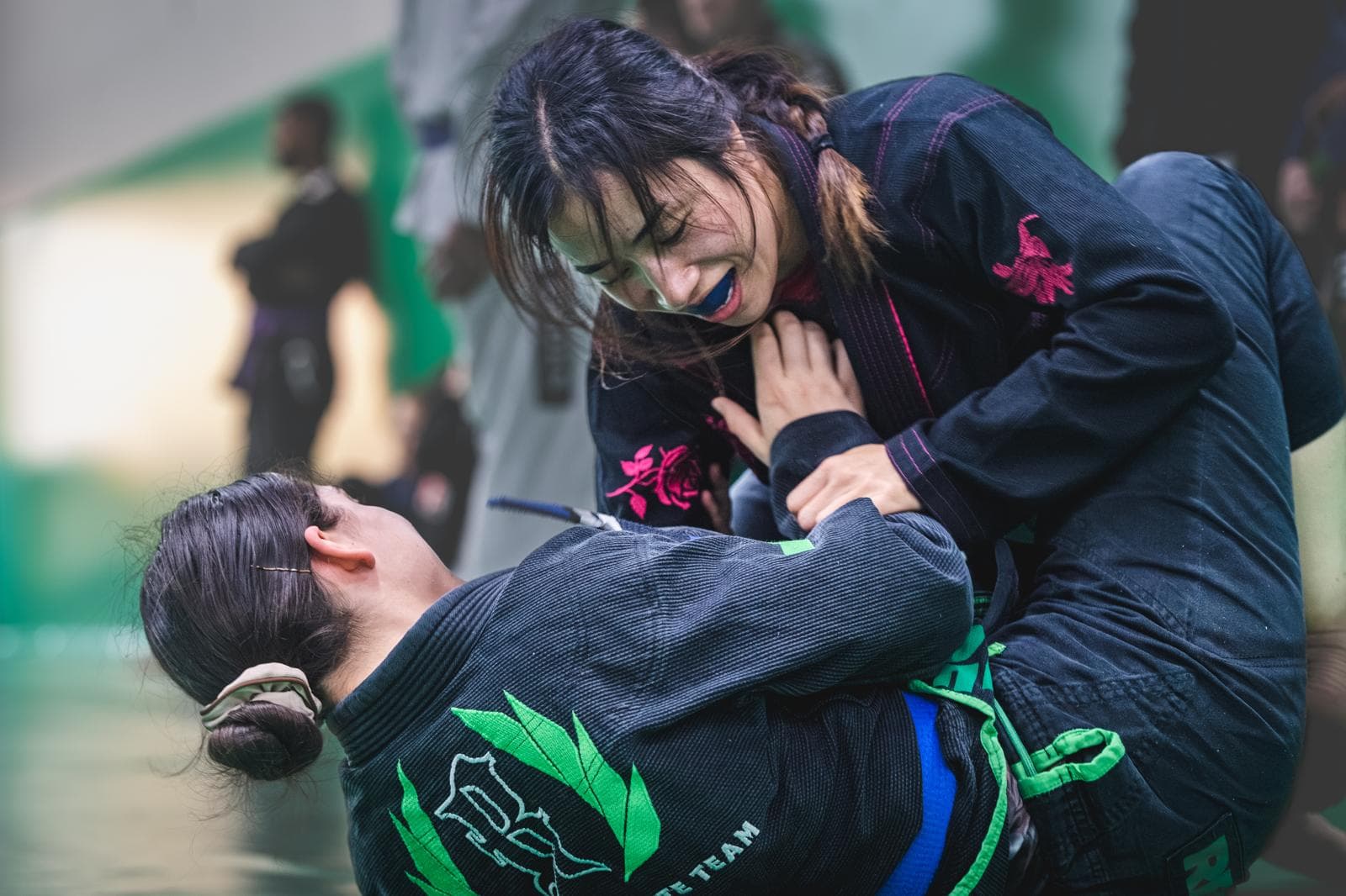 Two women rolling in the art of Brazilian Jiu-Jitsu